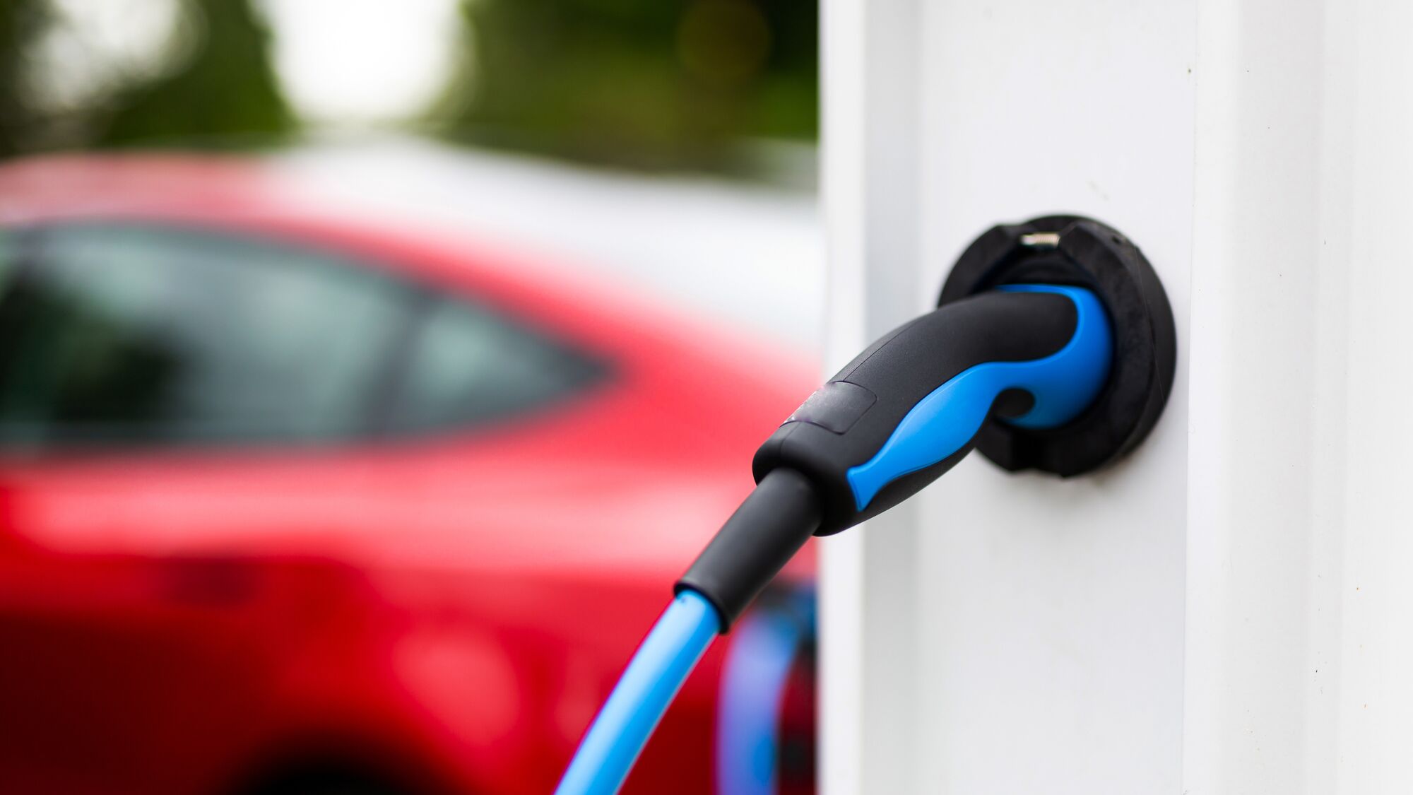Electric car charging at plug in charge station in a public car park in Suffolk, UK